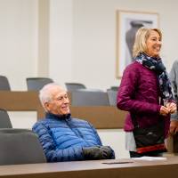 man sits down in classroom during tour